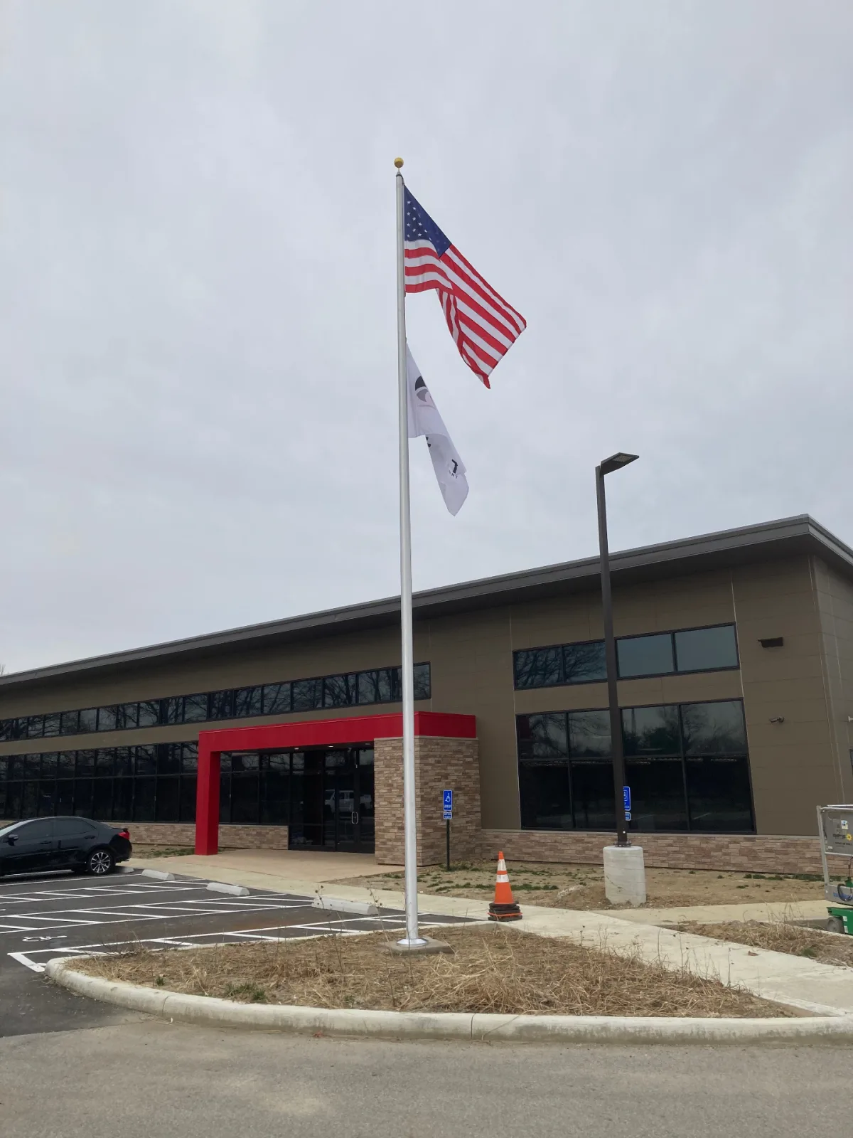 Commercial aluminum flagpole at modern office building entrance