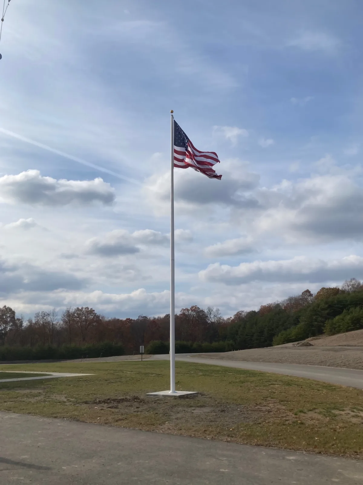 New commercial flagpole installation on prepared site with concrete base