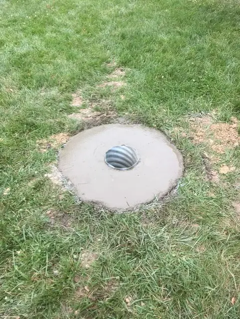 Concrete foundation tube set in ground for flagpole