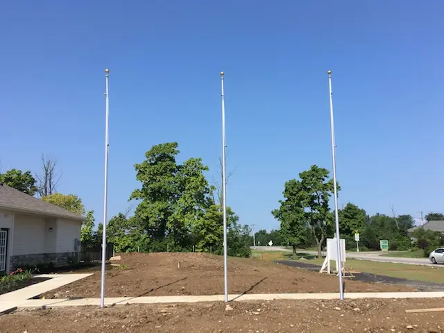 Three commercial flagpoles installed at business property